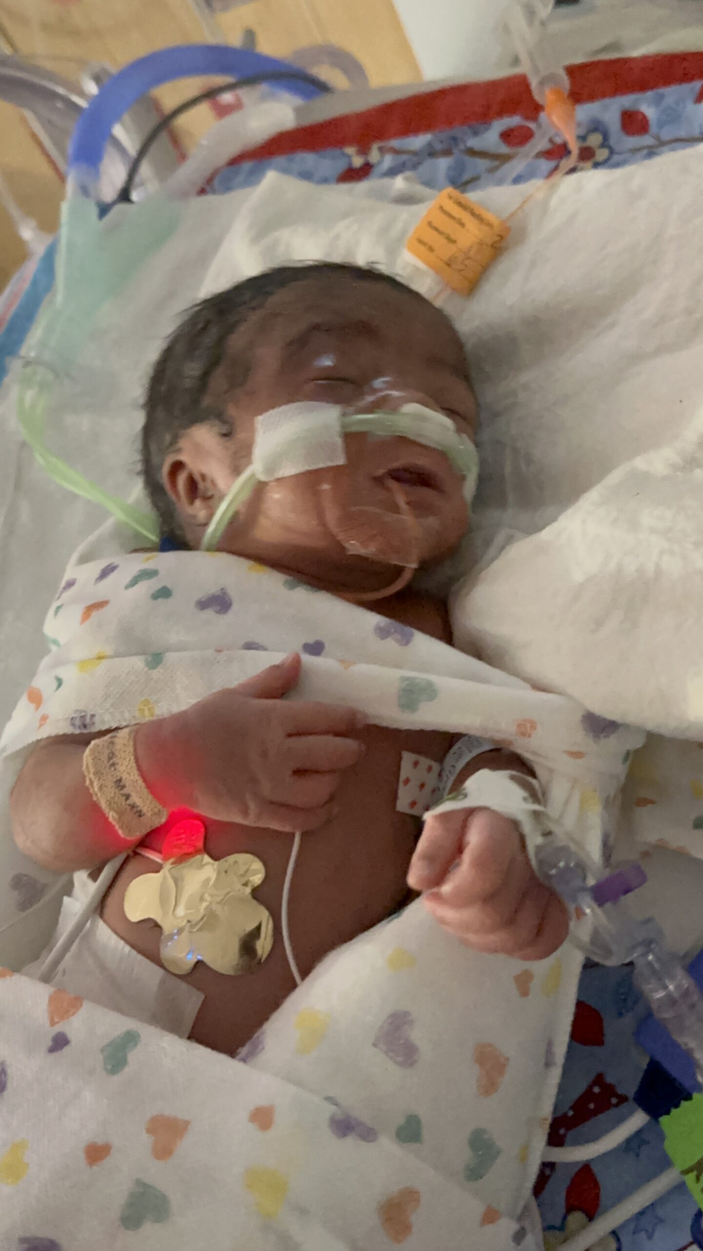 Smiling family holding a newborn baby, symbolizing hope after NICU journey